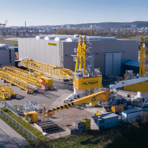 Wide shot of PALFINGER production site in Gdynia, Poland, showing parts of offshore cranes outside the halls currently in production