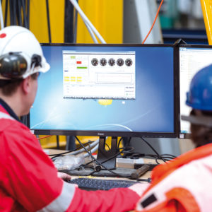 wo engineers examining a program on a desktop as part of the offshore crane tests.