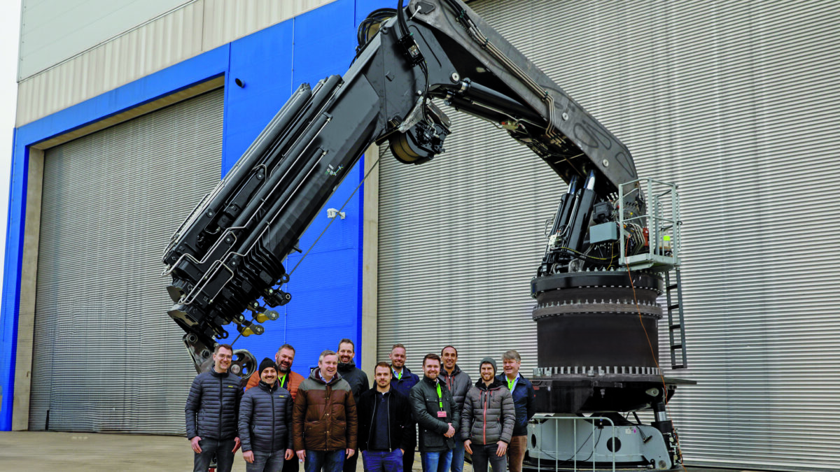 Group of people in front of heavy-duty foldable knuckle boom crane